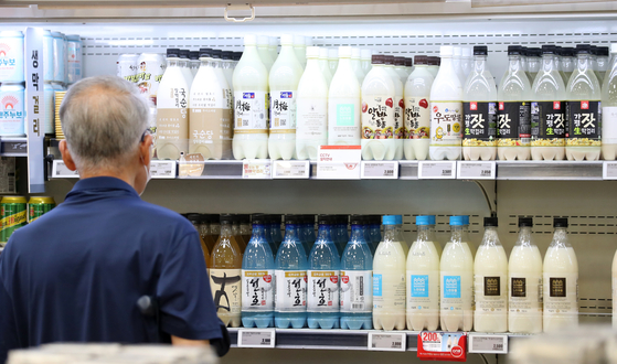 Bottles of makgeolli, a traditional Korean liquor made from rice, are displayed at a supermarket in Seoul on Friday. [NEWS1]
