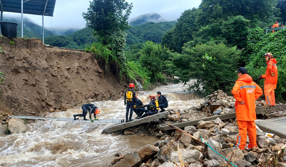 Firefighters conduct rescue operations at the scene of a landslide in Yecheon County, North Gyeongsang, on Saturday. [NEWS1] 