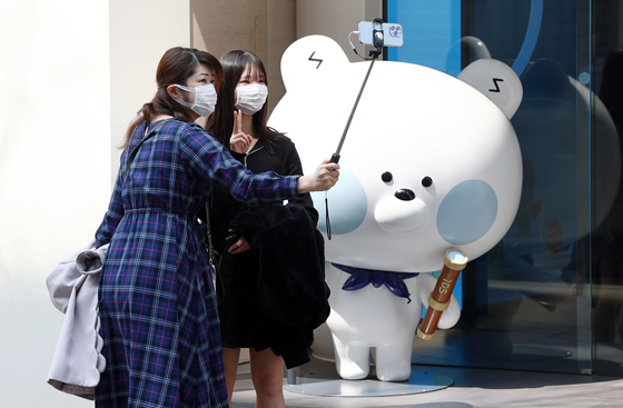 Japanese tourists take photos in Myeongdong, central Seoul, on March 29. [YONHAP]