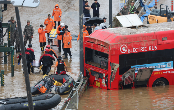 The bus that was submerged in a flooded underpass in Osong, North Chungcheong is recovered on Sunday, along with the bodies of seven victims. [YONHAP]