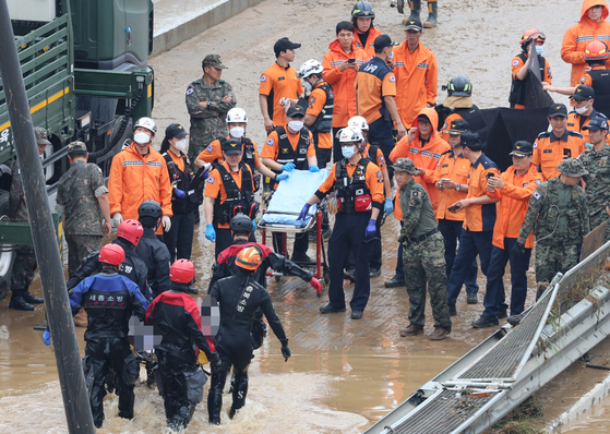 Emergency team carrying out a victim, who had died from the flooded underpass in Osong, North Chungcheong, on Saturday. The underpass was flooded after a levee along the nearby Miho River broke. [YONHAP] 