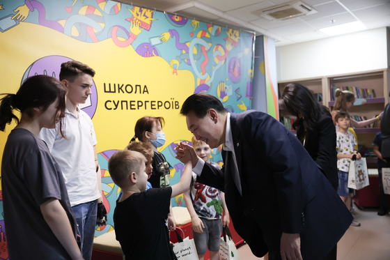 Korean President Yoon Suk Yeol, right, greets Ukrainian children at a national children's hospital in Kyiv on Saturday. [PRESIDENTIAL OFFICE]