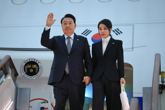 President Yoon Suk Yeol, left, and first lady Kim Keon-hee arrive on the presidential jet at Seoul Air Base in Seongnam, Gyeonggi, Monday morning after an eight-day trip that took them to Lithuania, Poland and a surprise stop in Ukraine. [PRESIDENTIAL OFFICE] 