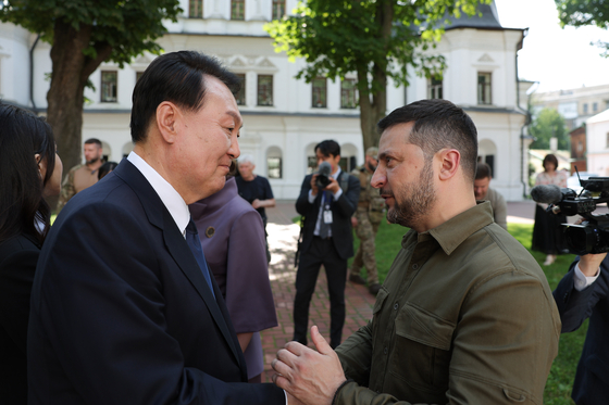 Korean President Yoon Suk Yeol, left, and Ukrainian President Volodymyr Zelensky chat in front of Saint Sophia Cathedral in Kyiv after their bilateral summit on Saturday. [PRESIDENTIAL OFFICE]