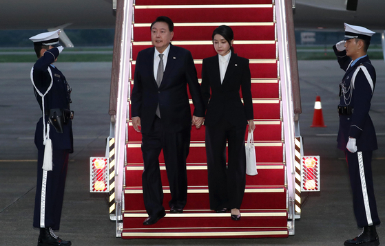 President Yoon Suk Yeol, left, and first lady Kim Keon-hee arrive on the presidential jet at Seoul Air Base in Seongnam, Gyeonggi, Monday morning after an eight-day trip that took them to Lithuania, Poland and Ukraine. [PRESIDENTIAL OFFICE]