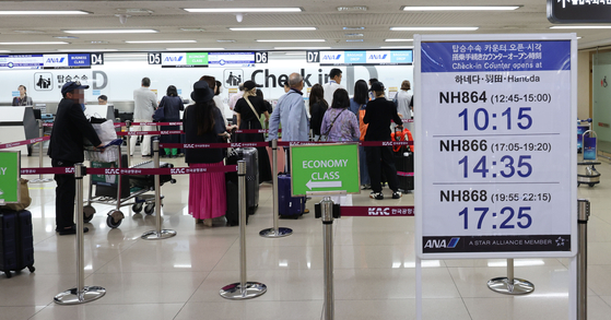 Passengers heading to Japan undergo boarding procedures at Gimpo Airport's international departure gate on Monday. According to the Ministry of Land, Infrastructure and Transport's aviation statistics, Japan-bound travelers surpassed those taking the Gimpo-Jeju route for the first time in four years from January to June this year. [YONHAP]