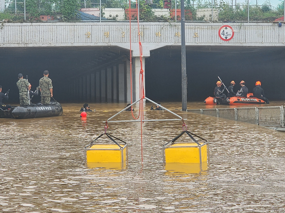 Firefighters and soldiers from the Republic of Korea Army Special Warfare Command conduct a search and rescue operation at the underpass on Sunday. [YONHAP]