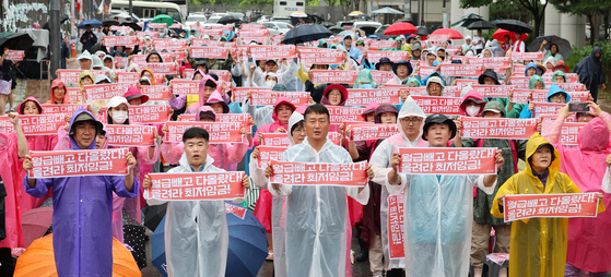 Union members of the Korea Confederation of Trade Unions, one of the country's two largest umbrella unions, hold a rally on Tuesday demanding a minimum wage increase for next year in front of the office building of the Ministry of Employment and Labor at the government complex in Sejong, where this year's 14th wage-setting meeting took place. The Minimum Wage Commission, a trilateral committee composed of representatives from labor and management sectors and the public, is expected to take a vote to decide on the amount of increase for next year's minimum wage as early as late Tuesday. [YONHAP] 