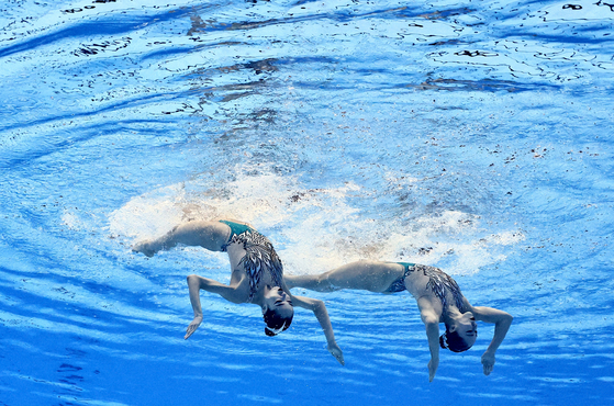 Korea's Hur Yoon-seo and Lee Ri-young perform during the artistic swimming women's duet free preliminary round at the 2023 World Aquatics Championships at the Marine Messe Fukuoka Hall A in Fukuoka, Japan on Tuesday. The Korean pair narrowly missed out on a spot in the final, finishing 13th out of 37 teams with only 12 advancing to the final on Thursday.  [REUTERS/YONHAP]
