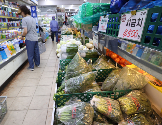 Customers shop for groceries at Yeongcheon traditional market in Seodaemun District, western Seoul, on Tuesday. The recent heavy rainfall has pushed up grocery prices, with the price of spinach soaring 219 percent to 54,780 won ($43.4) per 4 kilograms (9 pounds) compared to the previous month and red leaf lettuce rising 195 percent to 57,040 won, according to data compiled by the Korea Agro-Fisheries & Food Trade Corporation. [YONHAP]