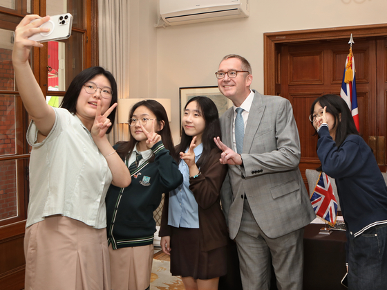 British Ambassador to Korea Colin Crooks, second from right, takes a selfie with winners of the essay writing contest at the British embassy in Seoul on Monday. [PARK SANG-MOON]