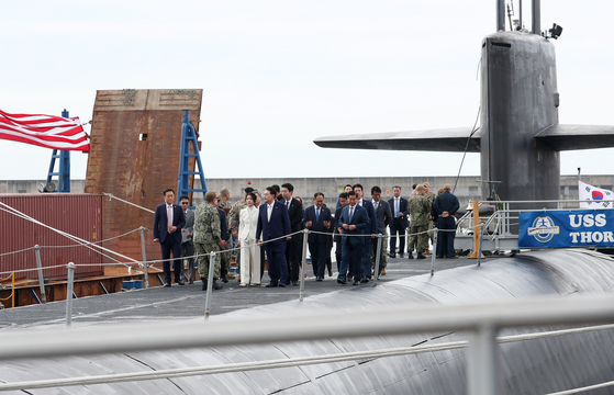 President Yoon Suk Yeol, accompanied by first lady Kim Keon-hee and other aides, tours the USS Kentucky, a U.S. nuclear-capable ballistic missile submarine (SSBN), docked at a naval base in Busan on Wednesday. [JOINT PRESS CORPS]