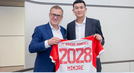 Kim Min-jae poses with Bayern Munich CEO Jan-Christian Dreesen after signing with the German club on Tuesday.  [SCREEN CAPTURE]