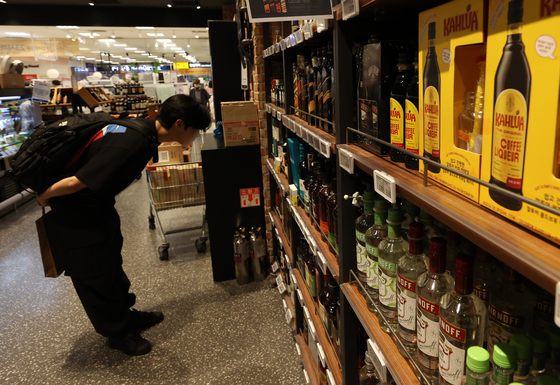 A customer looks at whiskey bottles at an Emart in downtown Seoul on Wednesday. Korea's whiskey imports jumped 50 percent on year in the first half of the year, an all-time high six-month figure since 2000 when Korea Customs Service started collecting related data. [YONHAP]