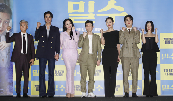 From left, actors Kim Jong-soo, Zo In-sung, Kim Hye-soo, director Ryoo Seung-wan, actors Yum Jung-ah, Park Jung-min and Go Min-si pose for a photo during a press conference for ″Smugglers″ held at CGV Yongsan in central Seoul on Tuesday. [NEWS1]