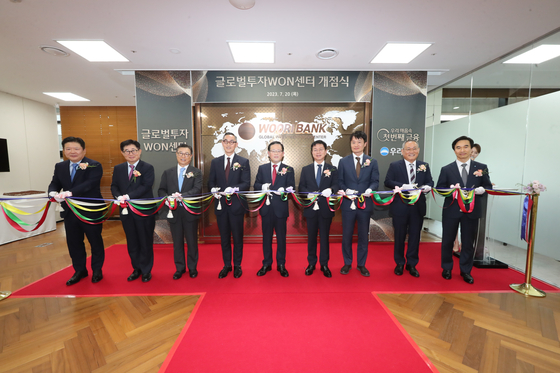 Woori Bank CEO Cho Byung-kyu, center, poses for a photo at the opening ceremony of the Global Investment WON Center in southern Seoul on Thursday. [WOORI BANK]