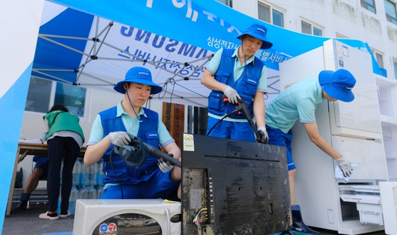 Samsung Electronics donated 3 billion won ($2.4 million) to the Hope Bridge Korea Disaster Relief Association on Thursday. The picture above shows Samsung engineers providing free repair services for its home appliances to flood victims. [SAMSUNG ELECTRONICS]