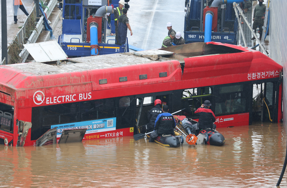 Rescue team searching for survivors on the bus that drowned in an underpass in Osong, North Chungcheong, on Sunday. Among the 13 people that died, five were on the bus including the driver. [YONHAP]