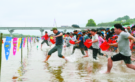 Visitors at the Hadong Seomjin River Corbicula Festival in Hadong County, South Gyeongsang, participate in a clam harvesting event. [BAEK JONG-HYUN]