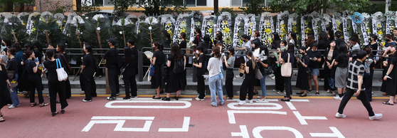 People including teachers line up in front of Seo 2 Elementary School in Seocho-dong, Seoul, on Friday to show their respect to the teacher, who committed suicide earlier this week. The death of the 23-year old teacher has raised national issues regarding the teachers' rights, which is considered to be heavily damaged. [YONHAP]