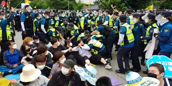 Some protestors and police clash during a rally held at the entry point of the Thaad site in Seongju County on June 15, 2021. [YONHAP] 