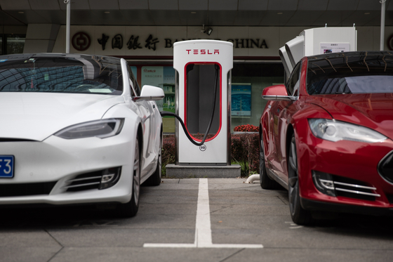 Tesla cars are charged at a charging station in front of the Tesla China headquarters in Beijing, China [EPA/YONHAP]