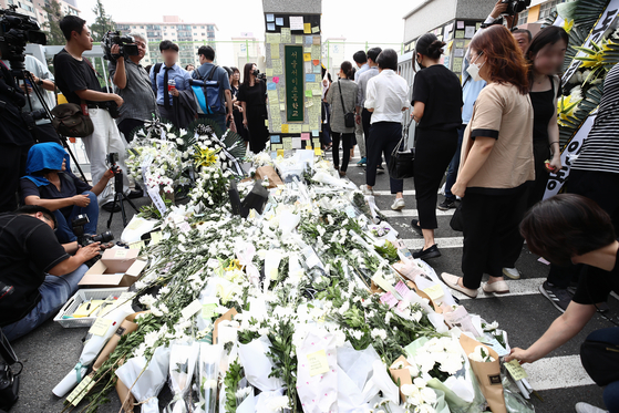Fellow teachers and other mourners leave flowers and notes at a makeshift memorial at the main gates of Seoul Seo 2 Elementary School in Seocho District, Seoul on Thursday after the death of a 23-year-old teacher at the school earlier this week. [NEWS1]