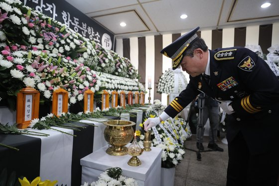 Commissioner General Yoon Hee-keun of the National Police Agency on Friday pays respect to victims of the flooding of an underpass in North Chungcheong at their joint memorial altar set up at the North Chungcheong provincial government building in Cheongju. [YONHAP] 