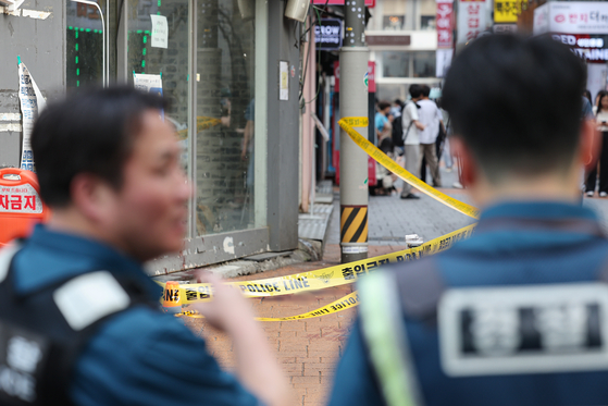 Police yellow tape wrapped around the scene where a man in his 30s attacked four people just outside of Sillim subway station on Friday. One died while three others were injured. [YONHAP]