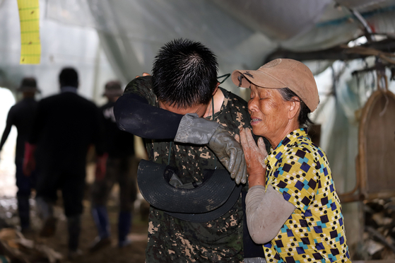 An elderly woman expresses her thanks to a soldier from the Korean Army's 35th Infantry Division involved in repairing flood damage in Mangseong-myeon in Iksan, North Jeolla, on Sunday. The area is one of 13 special disaster zones declared eligible for emergency relief on Wednesday after being battered by monsoon rains. [YONHAP]