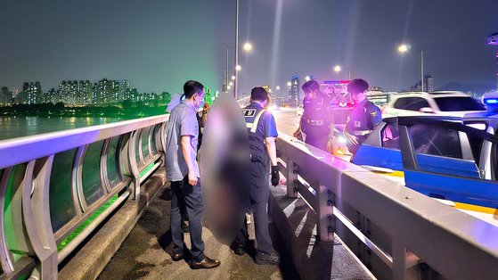 The Gwangjin police rescue a student who attempted to take their own life on Jamsil Bridge on June 30. [JANG SEO-YUN] 
