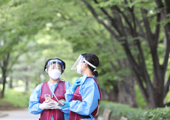 Staffers at a screening clinic in Daegu chat with masks and face shields on July 6. [YONHAP]