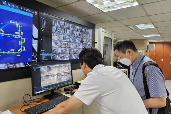Police officers on June 30 watch security camera footage at Guui Station to find a person with dementia reported missing. [JANG SEO-YUN] 