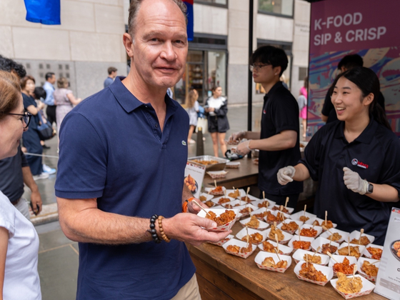 A man tries Korean chicken at a booth at the K-tourism Roadshow in New York City last week. [MINISTRY OF CULTURE, SPORTS AND TOURISM]