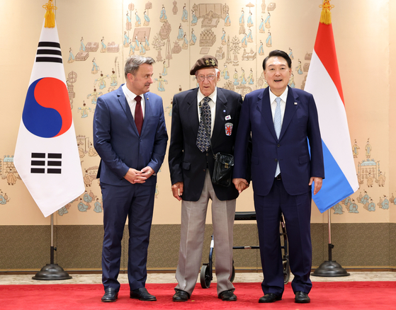 President Yoon Suk Yeol, right, poses for a commemorative photo with Luxembourg's Prime Minister Xavier Bettel, left, and Leon Moyen, a Korean War veteran, at the presidential office in Yongsan District, central Seoul, Tuesday, ahead of the 70th anniversary of the Armistice Agreement that brought a ceasefire. [JOINT PRESS CORPS]