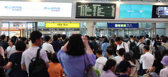 Passengers check their delayed train schedules on an electronic bulletin board at Seoul Station in central Seoul on Wednesday morning after a railway death near Gasan Digital Complex Station in southern Seoul led to major delays. [YONHAP]