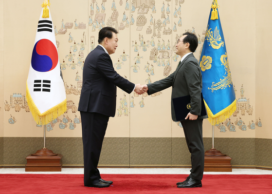 President Yoon Suk Yeol, left, presents new Korean Ambassador to Russia Lee Do-hoon with a letter of credence at the Yongsan presidential office in central Seoul Wednesday afternoon. [JOINT PRESS CORPS] 