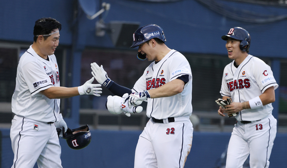 From left: Yang Eui-ji, Kim Jae-hwan and Heo Kyoung-min celebrate after Kim hit a two-run home run in a game against the Lotte Giants at Jamsil Baseball Stadium in southern Seoul on Tuesday. The Bears beat the Giants 8-5 to extend the team's winning streak to a club record 11 games.  [YONHAP]