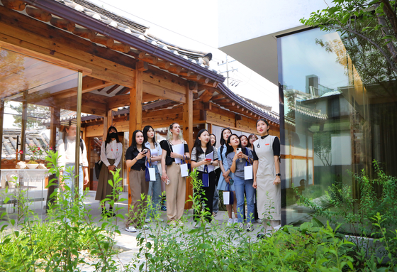 Students visiting the House of Sulwhasoo Bukchon in Jongno District, central Seoul, listen to a docent giving a tour. [PARK SANG-MOON]