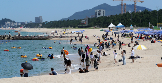 Vacationers enjoy Gangmun Beach in Gangneung, Gangwon, on Wednesday as the national weather agency announced an official end to this year’s monsoon season. [YONHAP]