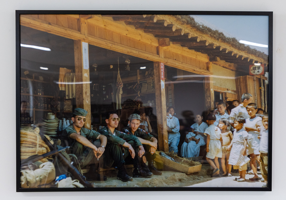 André Datcharry, second from left, sits alongside two other French soldiers on the porch of a shop in Korea in this photograph taken on his Nikon camera. Twenty of Datcharry's photos were displayed in a special exhibition at the Korean Cultural Center in Paris from June 16 to July 15. [NEWS1]
