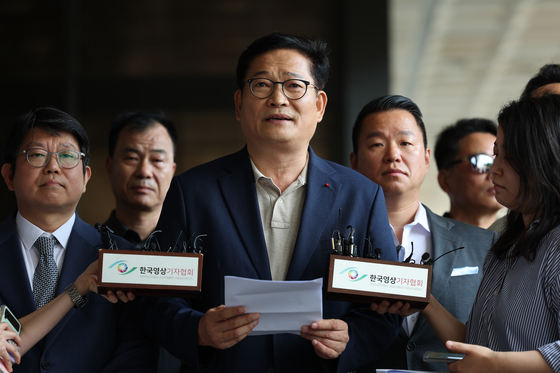 Song Young-gil, center, former chairman of the Democratic Party, speaks in front of reporters on Tuesday at the Seoul Central District Prosecutors’ Office in Seocho District, southern Seoul, after filing a complaint against President Yoon Suk Yeol accusing him of lying about a fraud case concerning his mother-in-law. [YONHAP] 