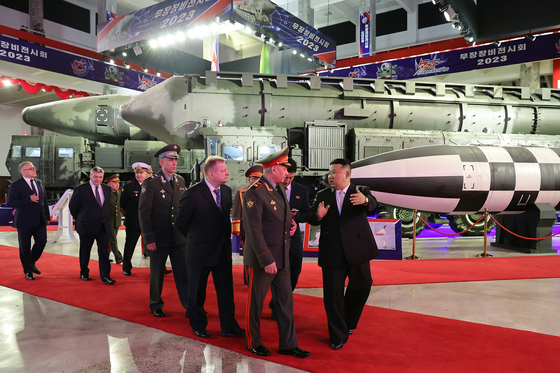 In this photo published by the Workers' Party-controlled newspaper Rodong Sinmun, North Korean leader Kim Jong-un, right, guides a Russian military delegation led by Defense Minister Sergei Shoigu through an exhibition of the North's latest weapons on Wednesday. A camouflage-painted Hwasong-17 intercontinental ballistic missile can be seen in the far background. [NEWS1]