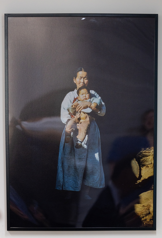 A woman holds a toddler in a photo taken by French Korean War veteran André Datcharry during his posting in Korea after the armistice. [NEWS1]