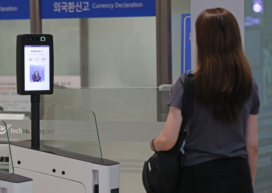 A traveler uses the Smartpass system, which facilitates departure procedures by using facial recognition, at Incheon International Airport on Friday. The system was rolled out at all departure areas and 16 boarding gates at the airport on Friday. [YONHAP]