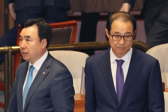 Reps. Youn Kwan-suk and Lee Sung-man await the final tallies of parliamentary votes regarding their arrest motions at the National Assembly in Yeouido, western Seoul, on June 12. The legislature voted to reject the arrest motions against both lawmakers. [YONHAP]