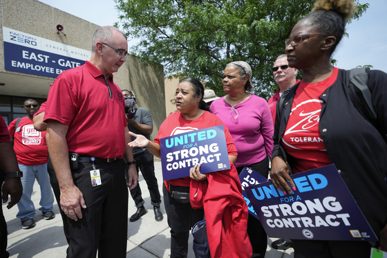 United Auto Workers President Shawn Fain, left, talks with autoworkers outside the General Motors Factory Zero plant in Hamtramck, Michigan on July 12. [AP/YONHAP]