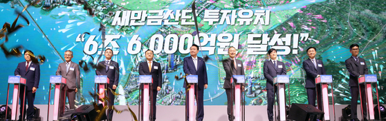 President Yoon Suk Yeol, center, and other delegates including LS Group Chairman Christopher Koo, fourth from right, attends an investment ceremony held at the Gunsan Saemangeum Convention Center in Gunsan County, North Jeolla, on Wednesday. [JOINT PRESS CORPS]