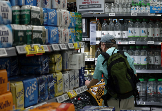 A customer passes by the alcohol section at a large supermarket in downtown Seoul on Tuesday. The government enabled discounts and sales of alcohol below the purchase cost as a measure to boost domestic consumption, allowing various retail stores, including supermarkets, convenience stores, restaurants and bars, to offer discounted prices on alcoholic beverages. [NEWS1]