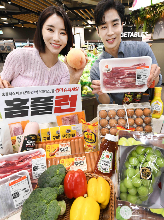 Models pose with event products sold under Homeplus' "Summer Super Sale Homeple Run" sales promotion on Wednesday. The sales promotion began on July 27 and runs through Aug. 16, offering up to 50 percent discount on daily supplies and food items. [YONHAP]